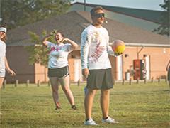 学生 playing dodgeball outside on campus.